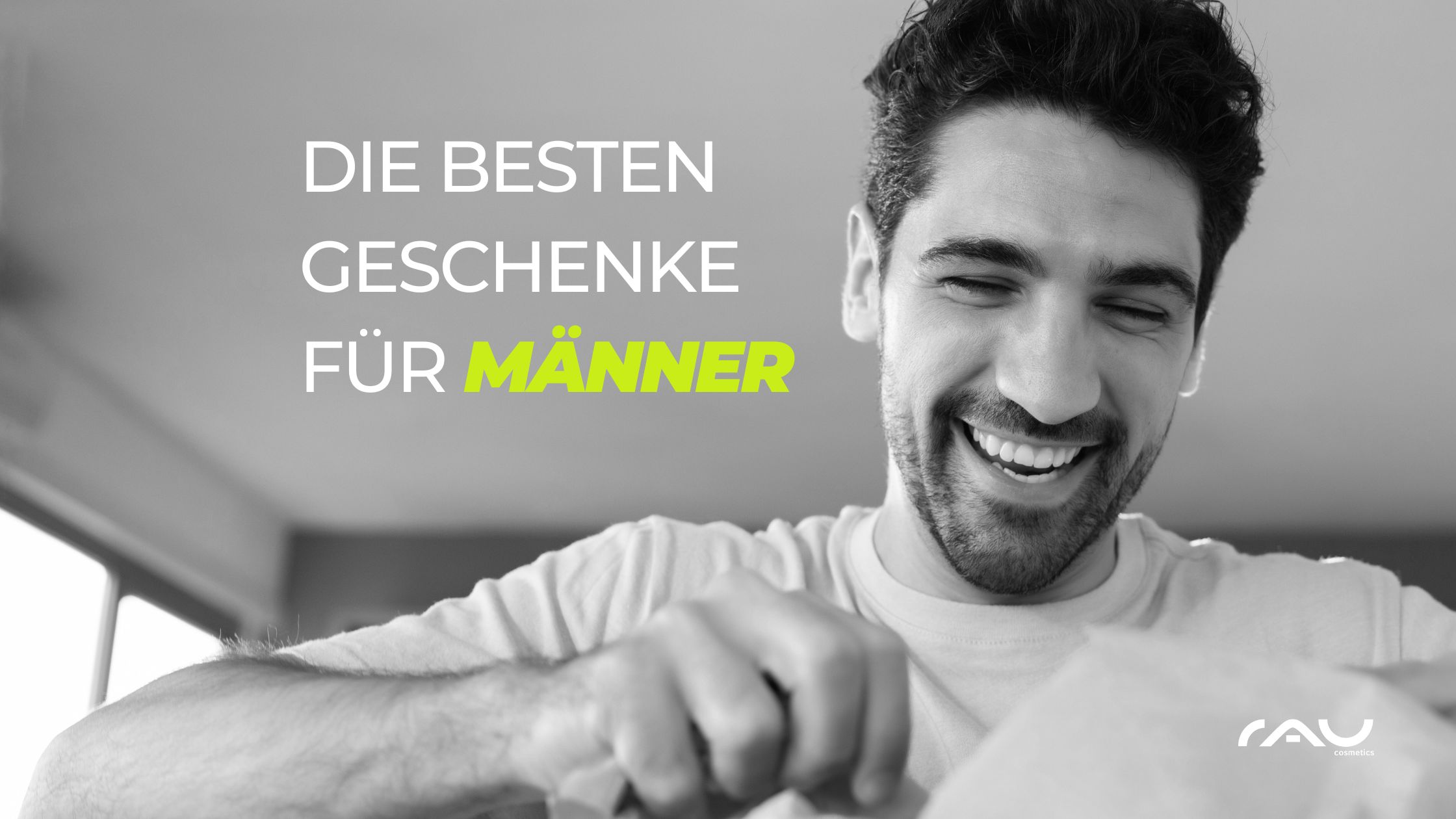 最适合男士的情人节礼物 Lächelnder Mann öffnet ein Geschenk, umgeben von der Aufschrift "Die besten Geschenke für Männer" in einem modernen, hellen Raum, passend zu Valentinstag Geschenkideen von RAU Cosmetics.